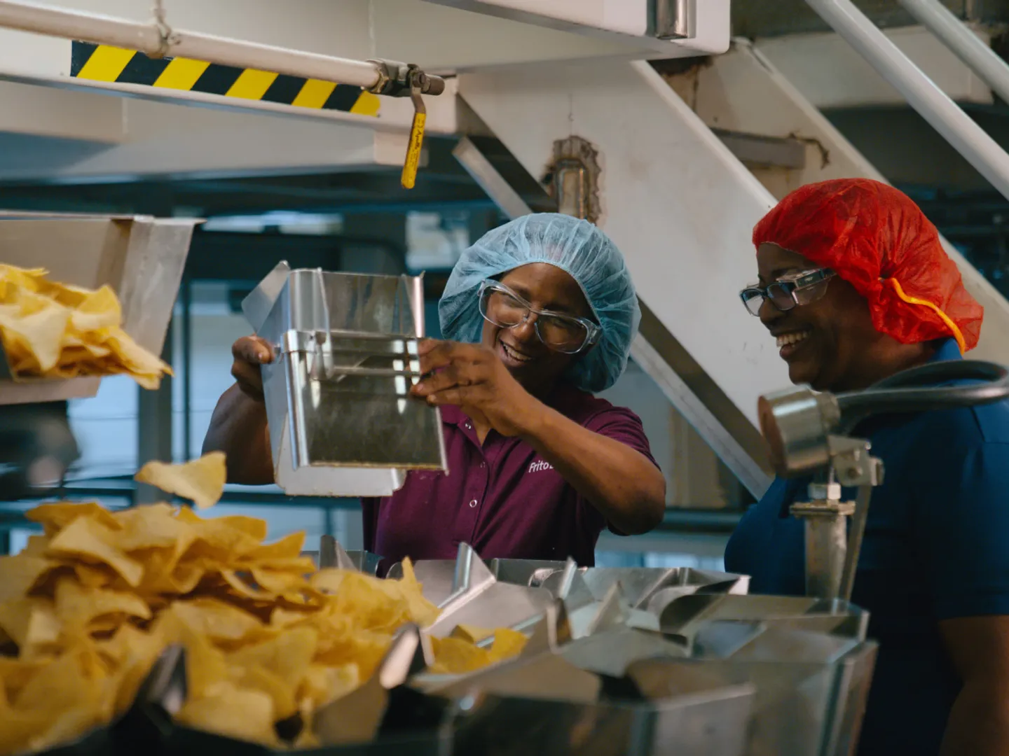 Two women inspecting chips in the Frito-Lay factory 